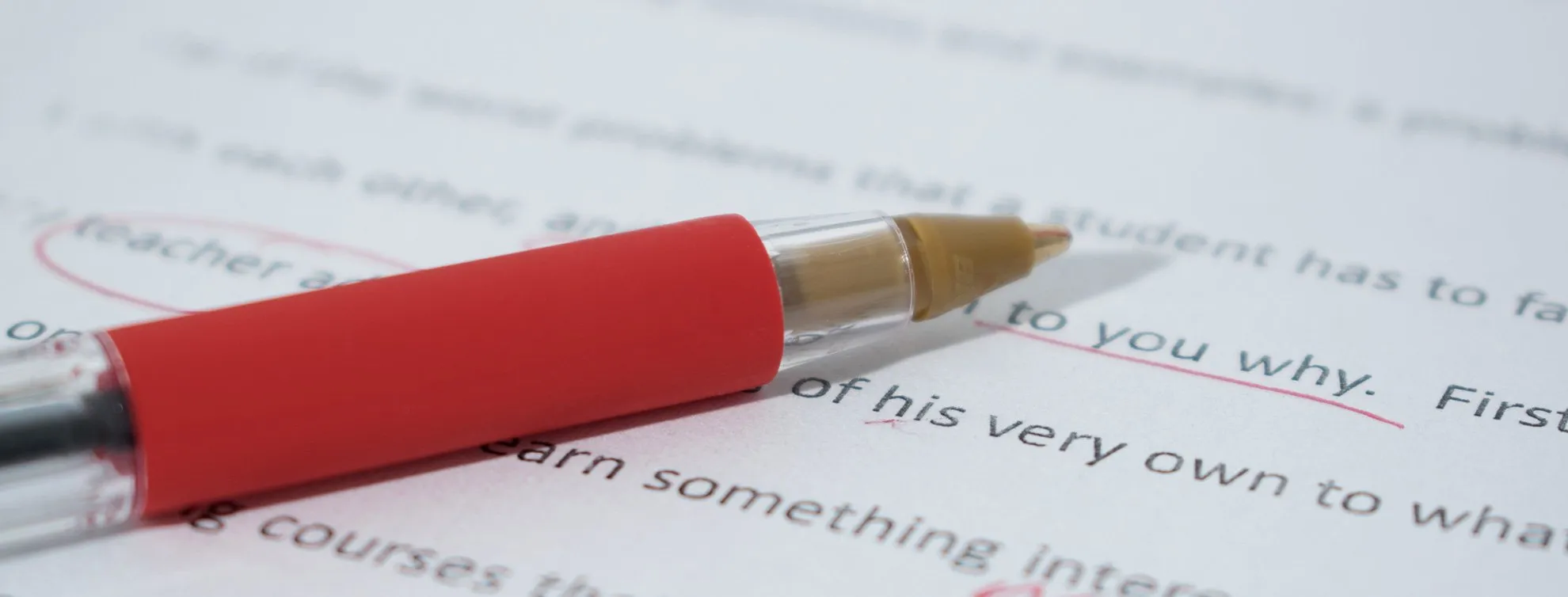 Roter Stift auf einem korrigierten Textdokument