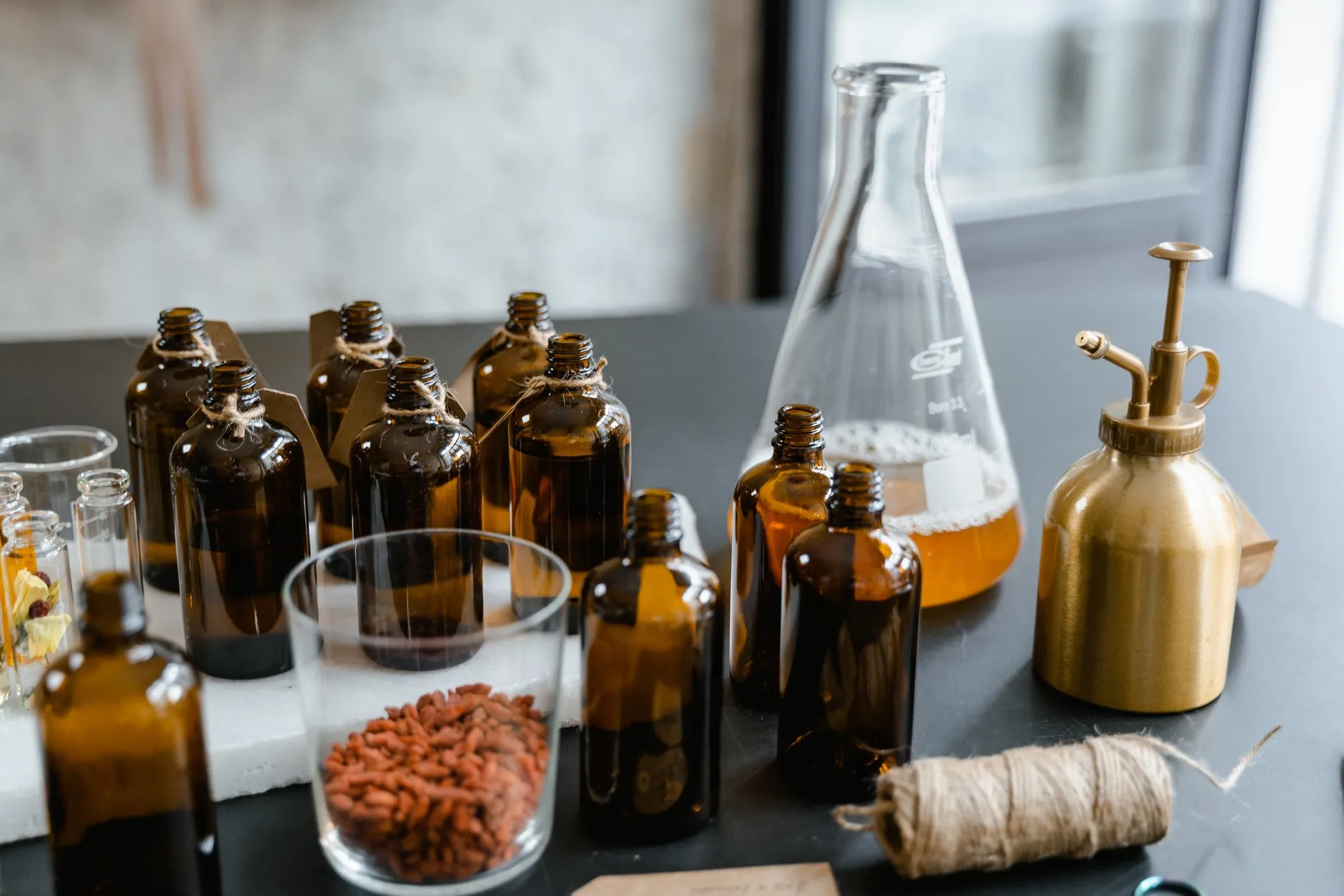 Braunglasflaschen, Erlenmeyerkolben und Rohstoffproben auf einem Labortisch