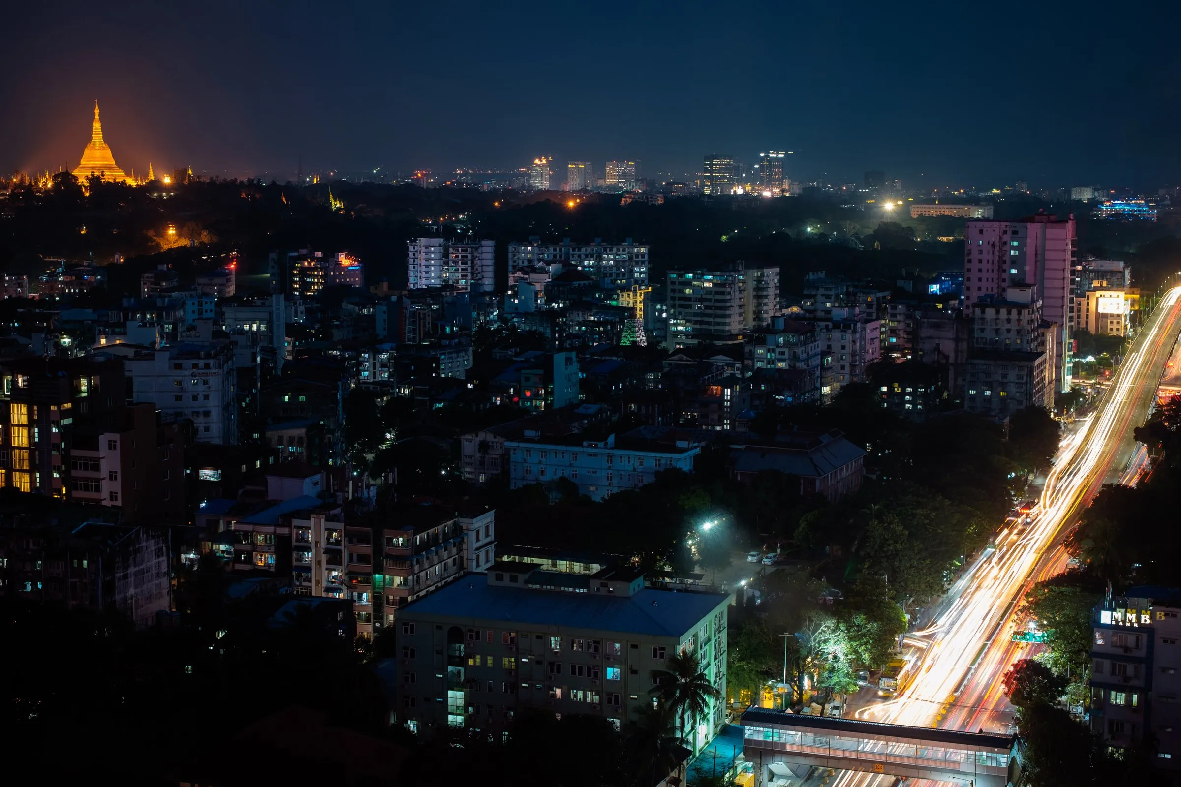 Stadt bei Nacht mit Lichtspuren auf einer Straße